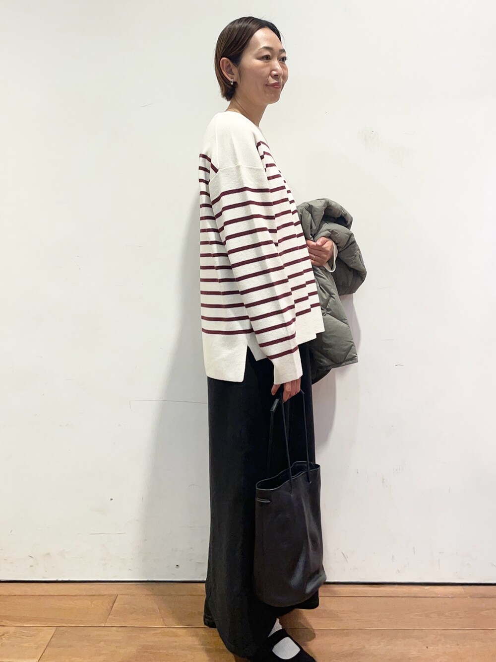 ブラック系のショルダーバッグ、レッド系のニット/セーター、グリーン系のその他アウターを着用したレディースの秋コーディネートの6枚目の写真