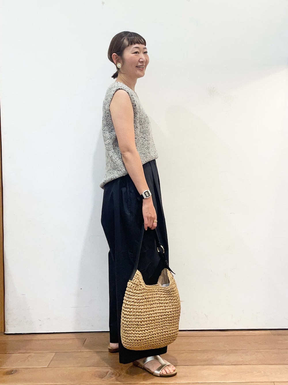 グレー系のニット/セーター、ゴールド系のサンダル、イエロー系のトートバッグを着用したレディースの夏コーディネートの3枚目の写真