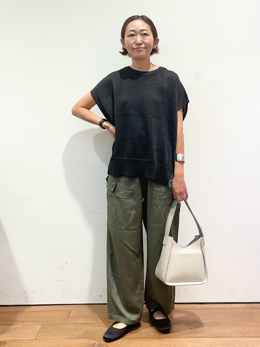 ブラック系のニット/セーター、グレー系のハンドバッグ、グリーン系のその他パンツを着用したレディースの秋コーディネートの2枚目の写真