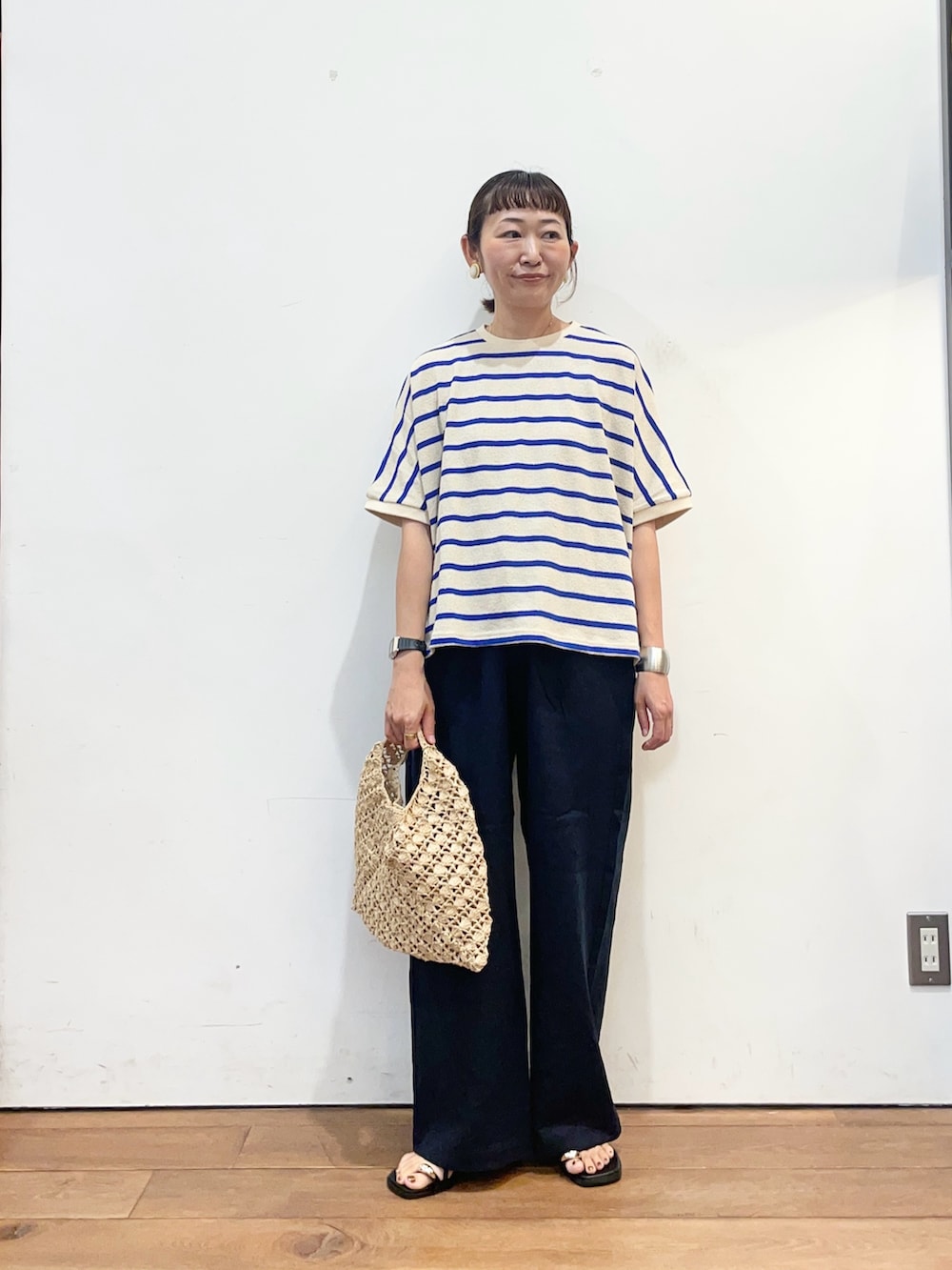 ブルー系のTシャツ/カットソー、ブルー系のその他パンツ、ベージュ系のハンドバッグを着用したレディースの夏コーディネートの2枚目の写真