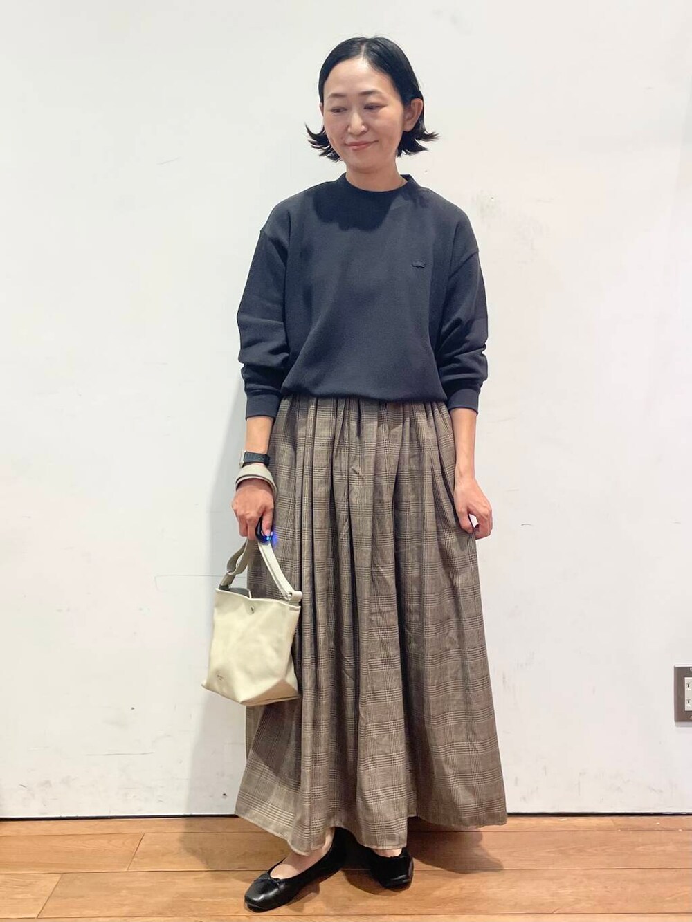 その他のスカート、ベージュ系のショルダーバッグ、ブラック系のTシャツ/カットソーを着用したレディースの秋コーディネートの2枚目の写真