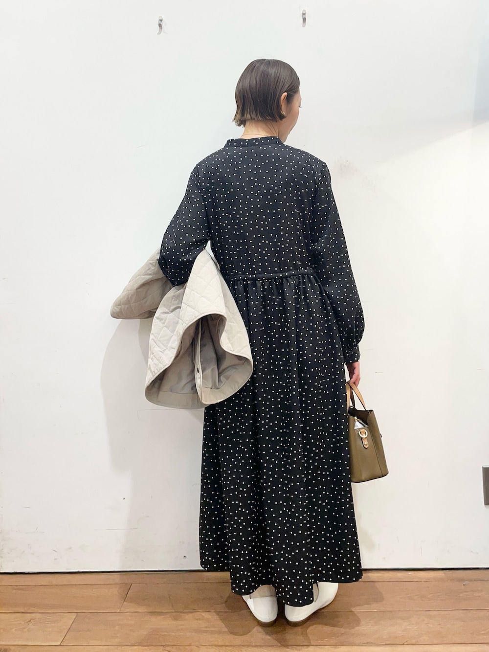 グレー系のダウンジャケット/コート、ホワイト系のその他シューズ、ブラック系のワンピースを着用したレディースの春コーディネートの8枚目の写真