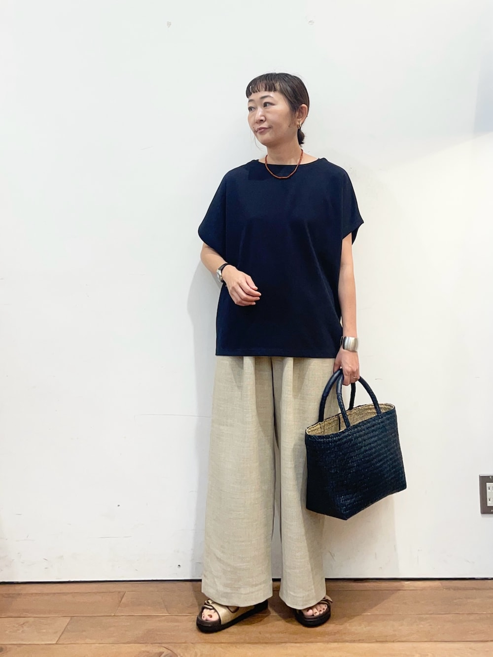ブルー系のTシャツ/カットソー、ベージュ系のサンダル、ブルー系のトートバッグを着用したレディースの夏コーディネートの2枚目の写真