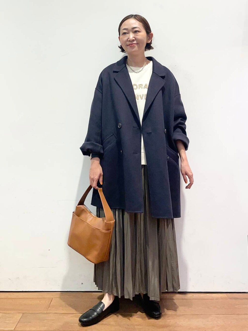 ブルー系のその他アウター、イエロー系のショルダーバッグ、ベージュ系のスカートを着用したレディースの秋コーディネートの2枚目の写真