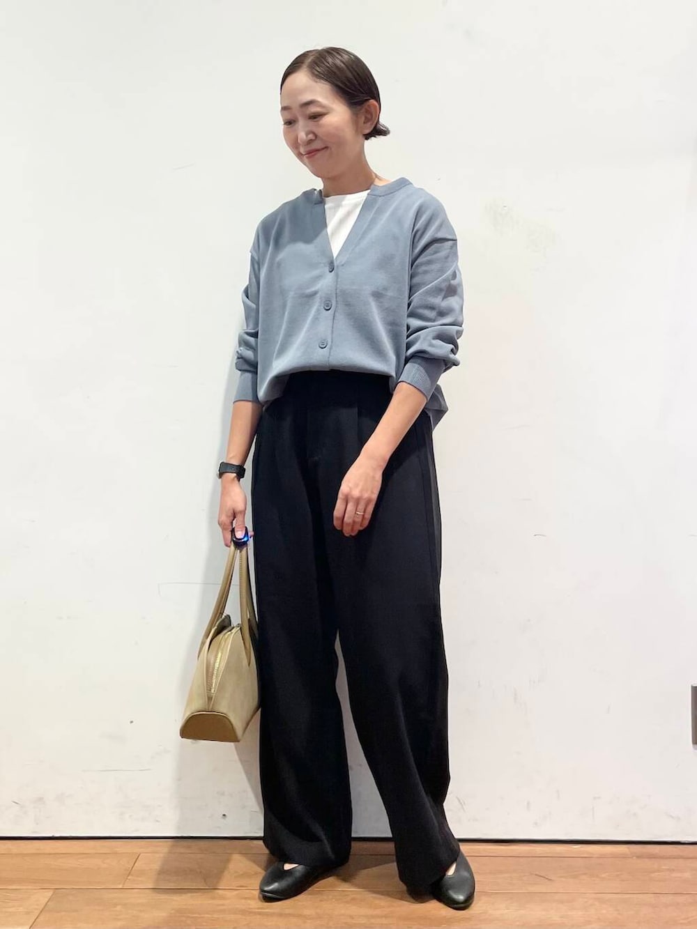 ブラック系のパンプス、ベージュ系のハンドバッグ、ホワイト系のTシャツ/カットソーを着用したレディースの秋コーディネートの2枚目の写真