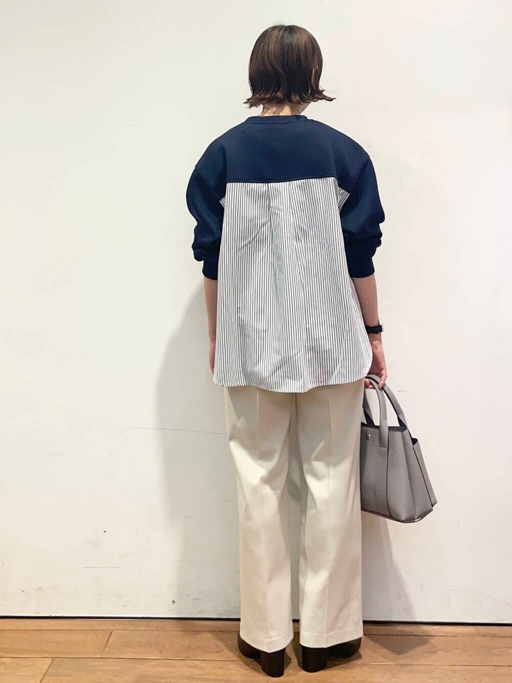 ブラック系のブーツ、ホワイト系のその他パンツ、グレー系のトートバッグを着用したレディースの冬コーディネートの5枚目の写真