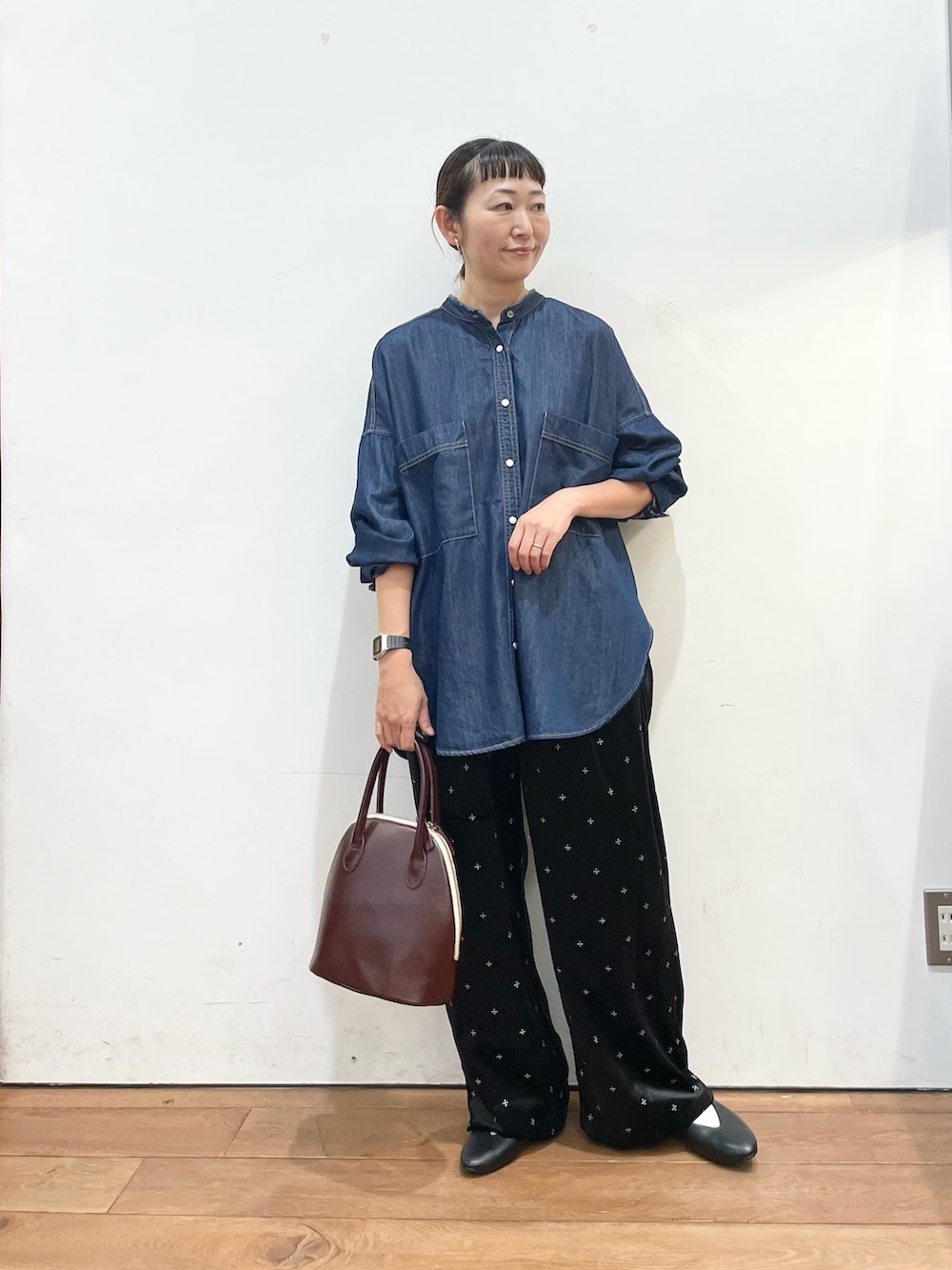 ブルー系のシャツ/ブラウス、レッド系のハンドバッグ、ブラック系のパンプスを着用したレディースの秋コーディネートの2枚目の写真