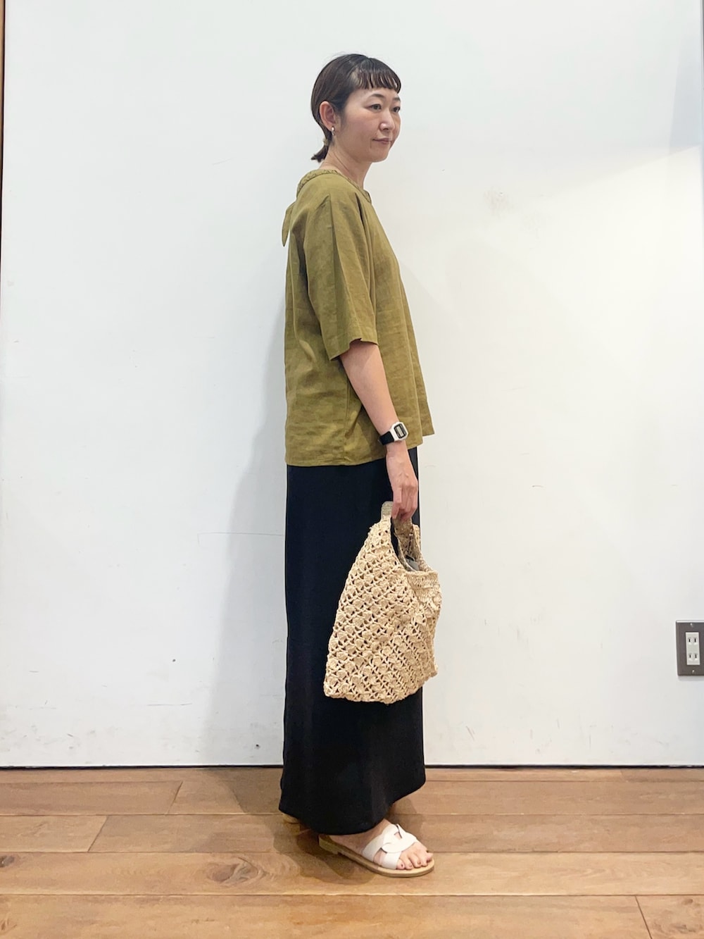 イエロー系のシャツ/ブラウス、ブラック系のスカート、ベージュ系のハンドバッグを着用したレディースの夏コーディネートの3枚目の写真