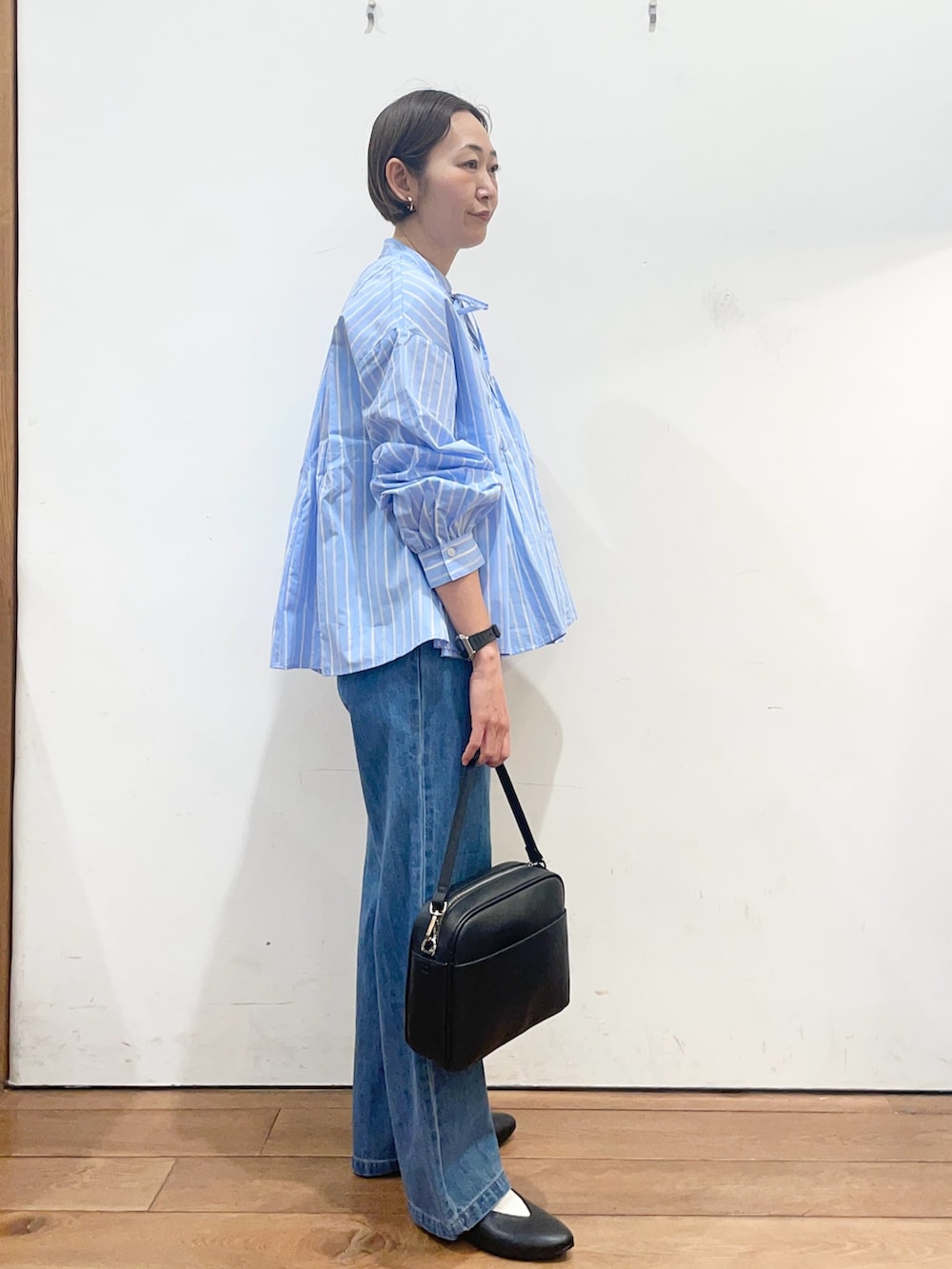 ブルー系のシャツ/ブラウス、ブラック系のショルダーバッグ、ブラック系のパンプスを着用したレディースの春コーディネートの3枚目の写真