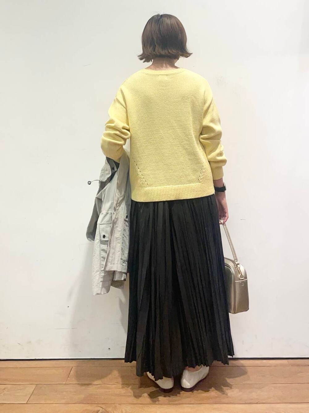 ゴールド系のショルダーバッグ、ブラック系のスカート、ホワイト系のバレエシューズを着用したレディースの春コーディネートの8枚目の写真