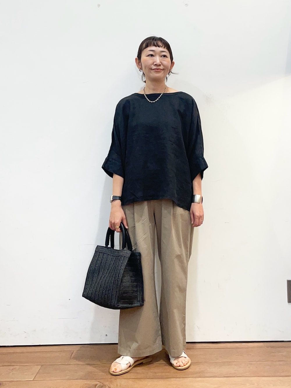 ブラック系のシャツ/ブラウス、ベージュ系のその他パンツ、ブラック系のハンドバッグを着用したレディースの夏コーディネートの2枚目の写真