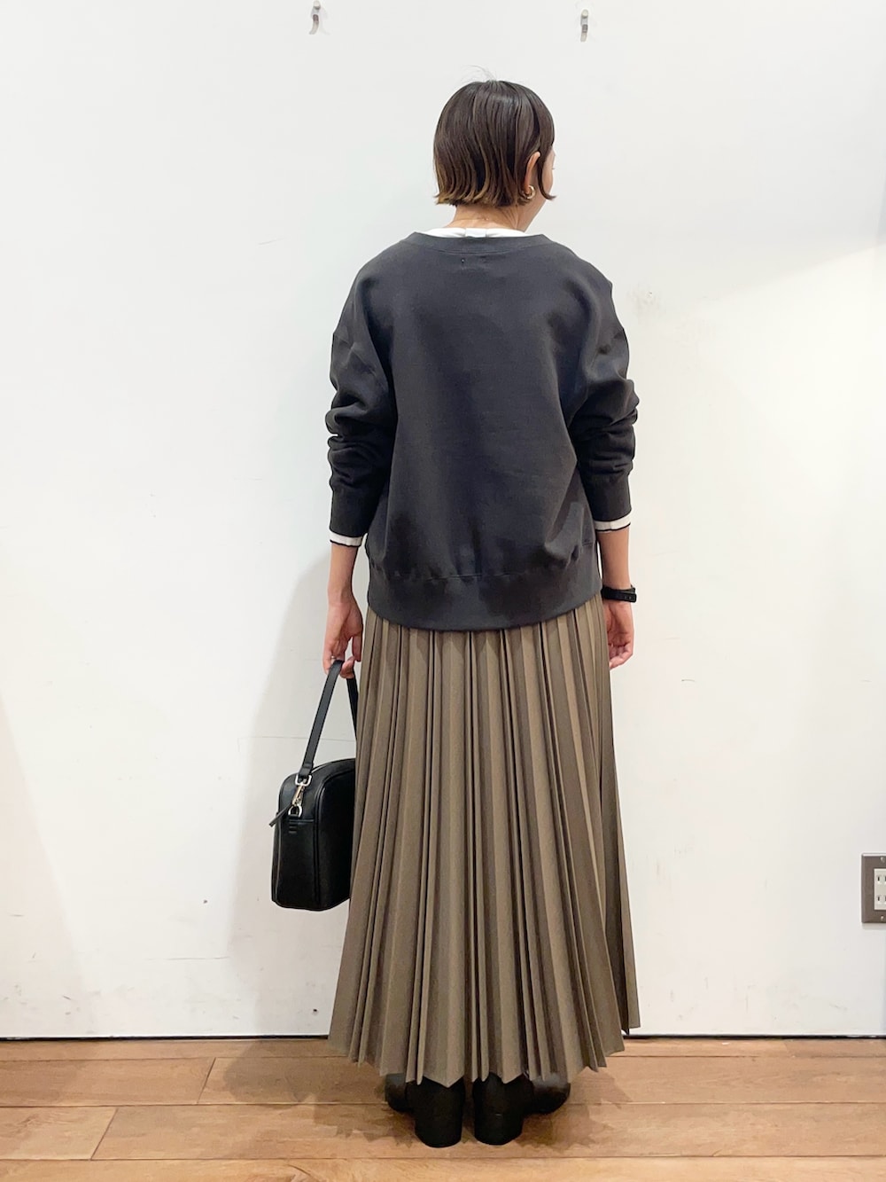 ベージュ系のスカート、ブラック系のショルダーバッグ、グレー系のカーディガン/ボレロを着用したレディースの冬コーディネートの4枚目の写真