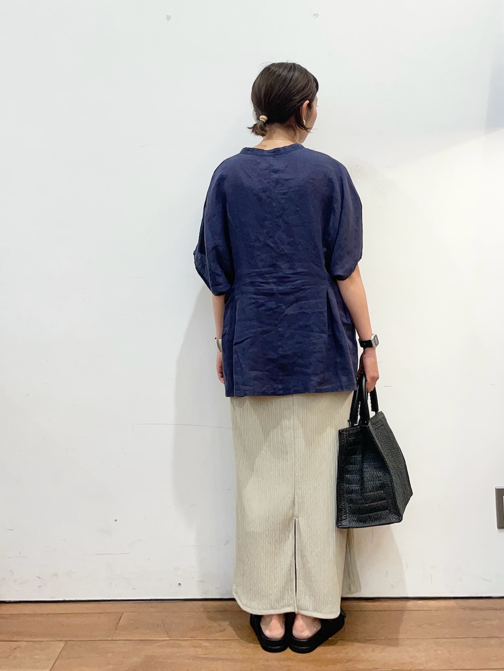 ブルー系のシャツ/ブラウス、ブラック系のハンドバッグ、ベージュ系のスカートを着用したレディースの夏コーディネートの4枚目の写真