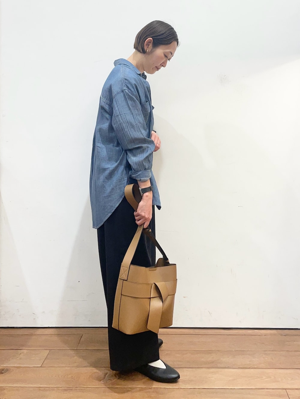 ブルー系のシャツ/ブラウス、ブラック系のパンプス、イエロー系のショルダーバッグを着用したレディースの春コーディネートの4枚目の写真