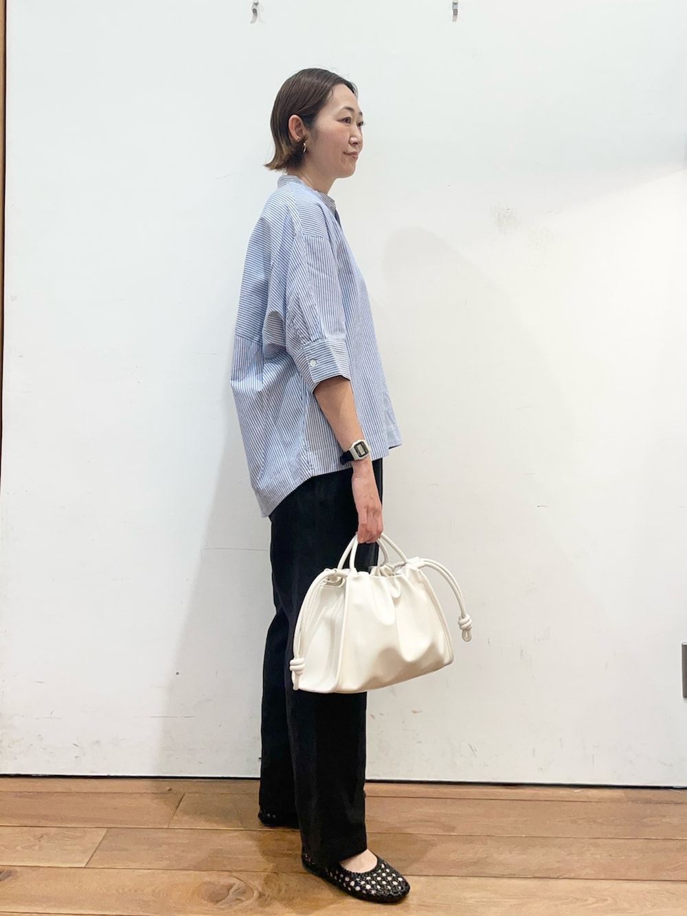 ブルー系のシャツ/ブラウス、ブラック系のその他パンツ、ホワイト系のトートバッグを着用したレディースの春コーディネートの3枚目の写真