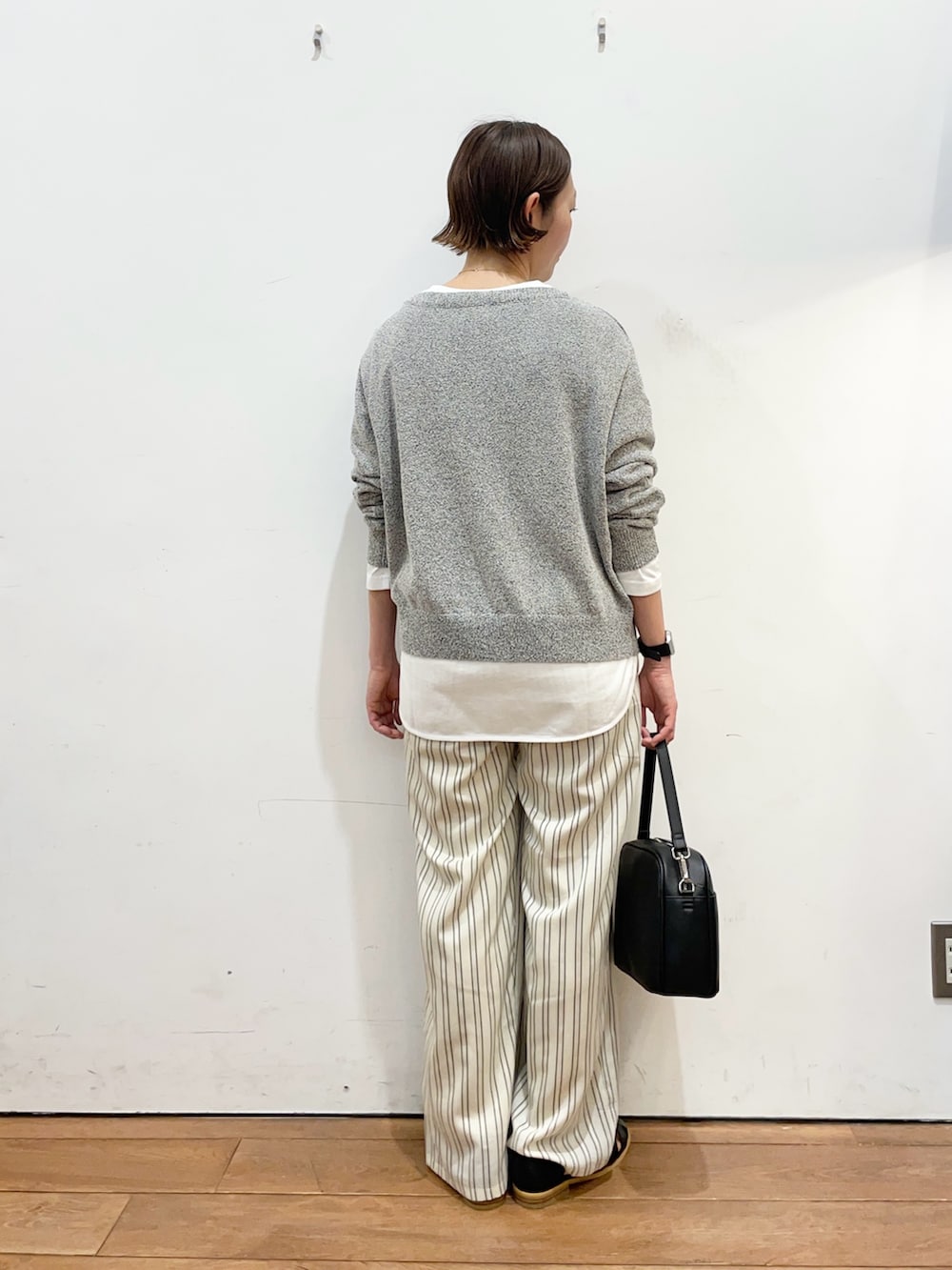 ブラック系のニット/セーター、ホワイト系のTシャツ/カットソー、ベージュ系のその他パンツを着用したレディースの春コーディネートの4枚目の写真