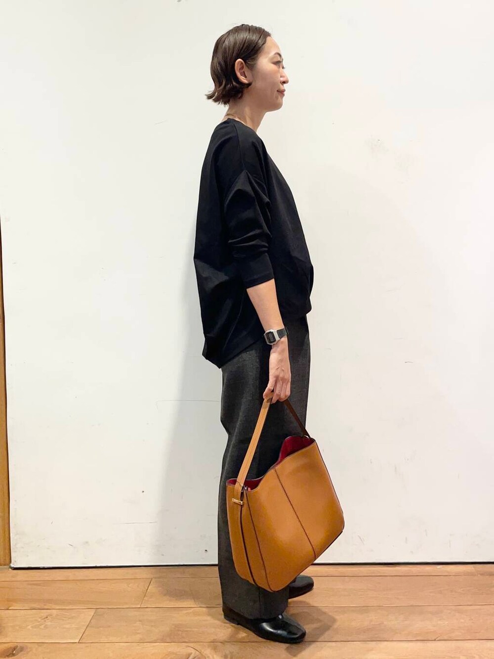 ブラウン系のハンドバッグ、ブラック系のTシャツ/カットソー、グレー系のその他パンツを着用したレディースの秋コーディネートの3枚目の写真