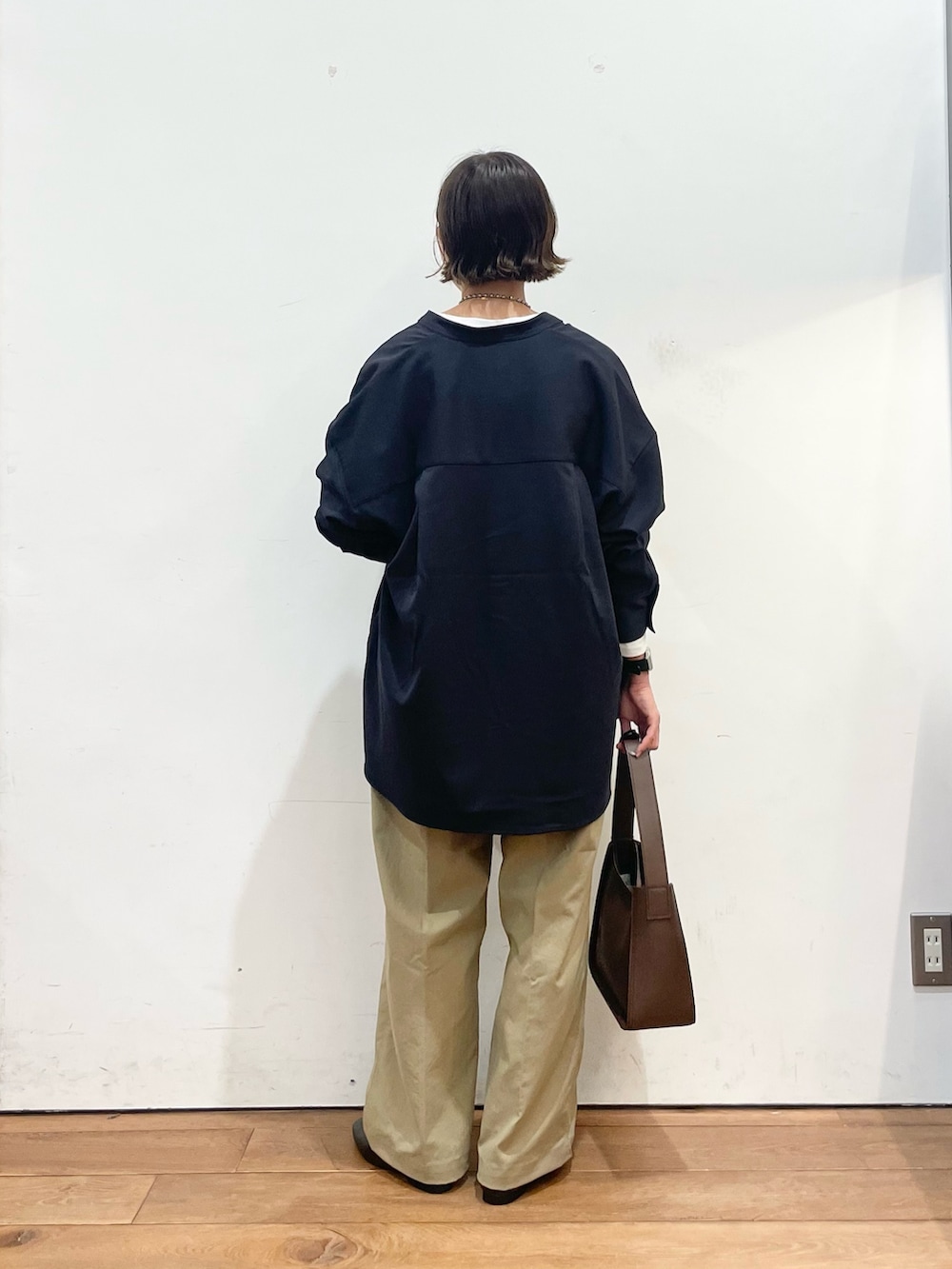 ホワイト系のTシャツ/カットソー、グレー系のシャツ/ブラウス、ベージュ系のその他パンツを着用したレディースの秋コーディネートの4枚目の写真