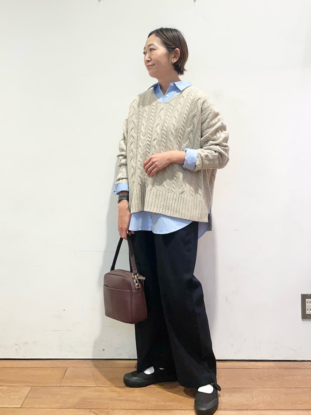 ベージュ系のニット/セーター、ブルー系のシャツ/ブラウス、ブラック系のバレエシューズを着用したレディースの秋コーディネートの3枚目の写真