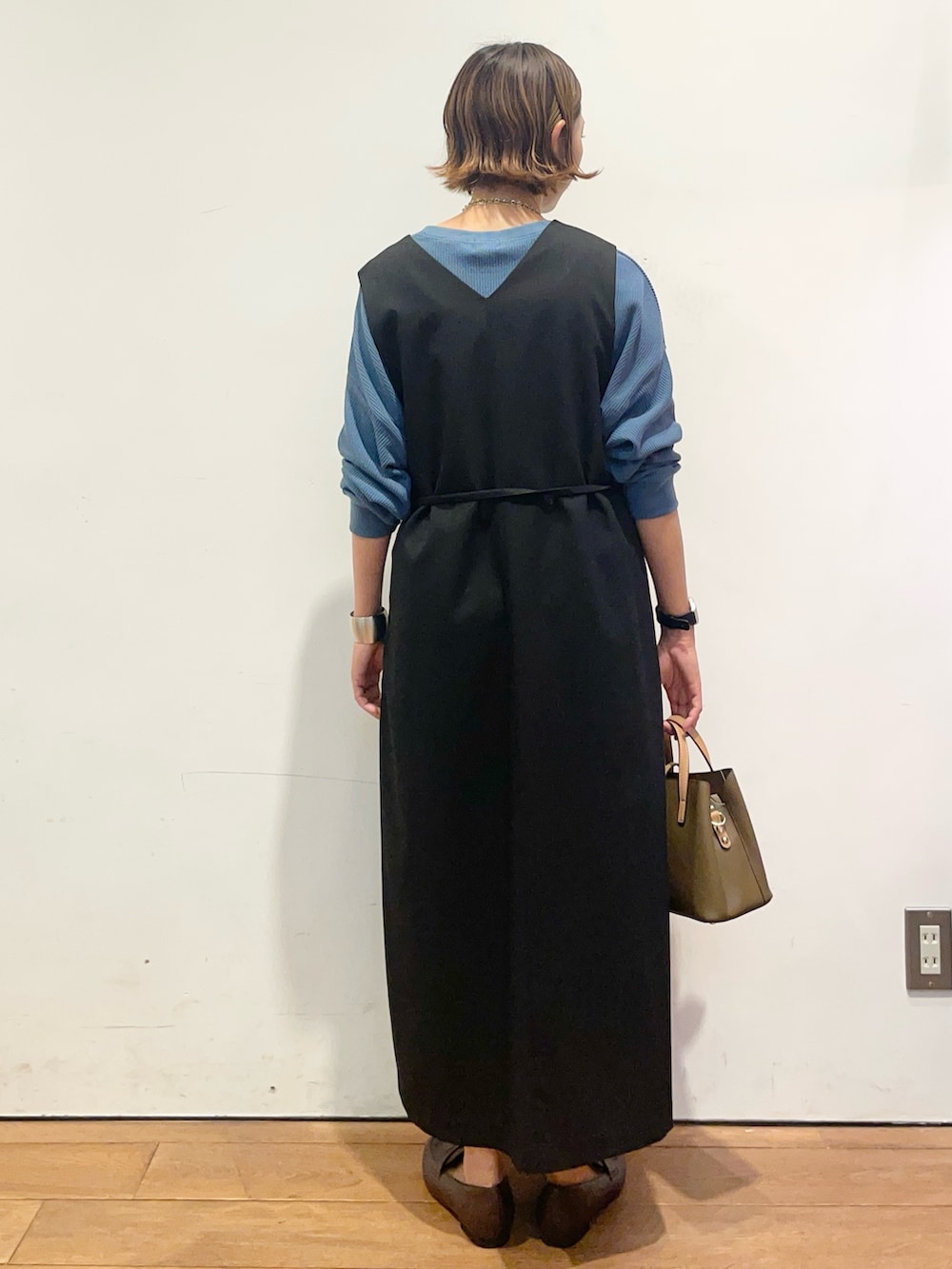 ブラック系のワンピース、ブルー系のTシャツ/カットソー、ブラウン系のパンプスを着用したレディースの秋コーディネートの6枚目の写真