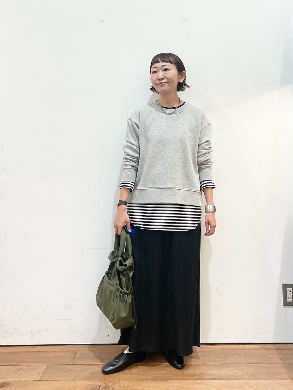 グレー系のスウェット、ホワイト系のTシャツ/カットソー、ブラック系のスリッポンを着用したレディースの秋コーディネートの3枚目の写真