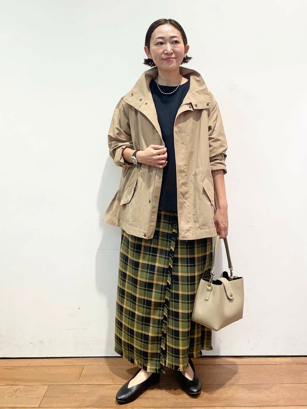 ブラック系のパンプス、ベージュ系のその他アウター、ベージュ系のショルダーバッグを着用したレディースの秋コーディネートの2枚目の写真