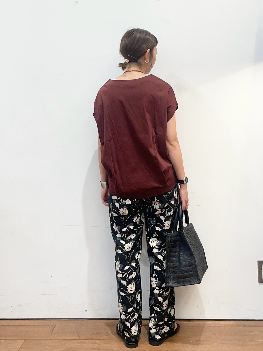 レッド系のTシャツ/カットソー、ブラック系のサンダル、ブラック系のハンドバッグを着用したレディースの夏コーディネートの4枚目の写真