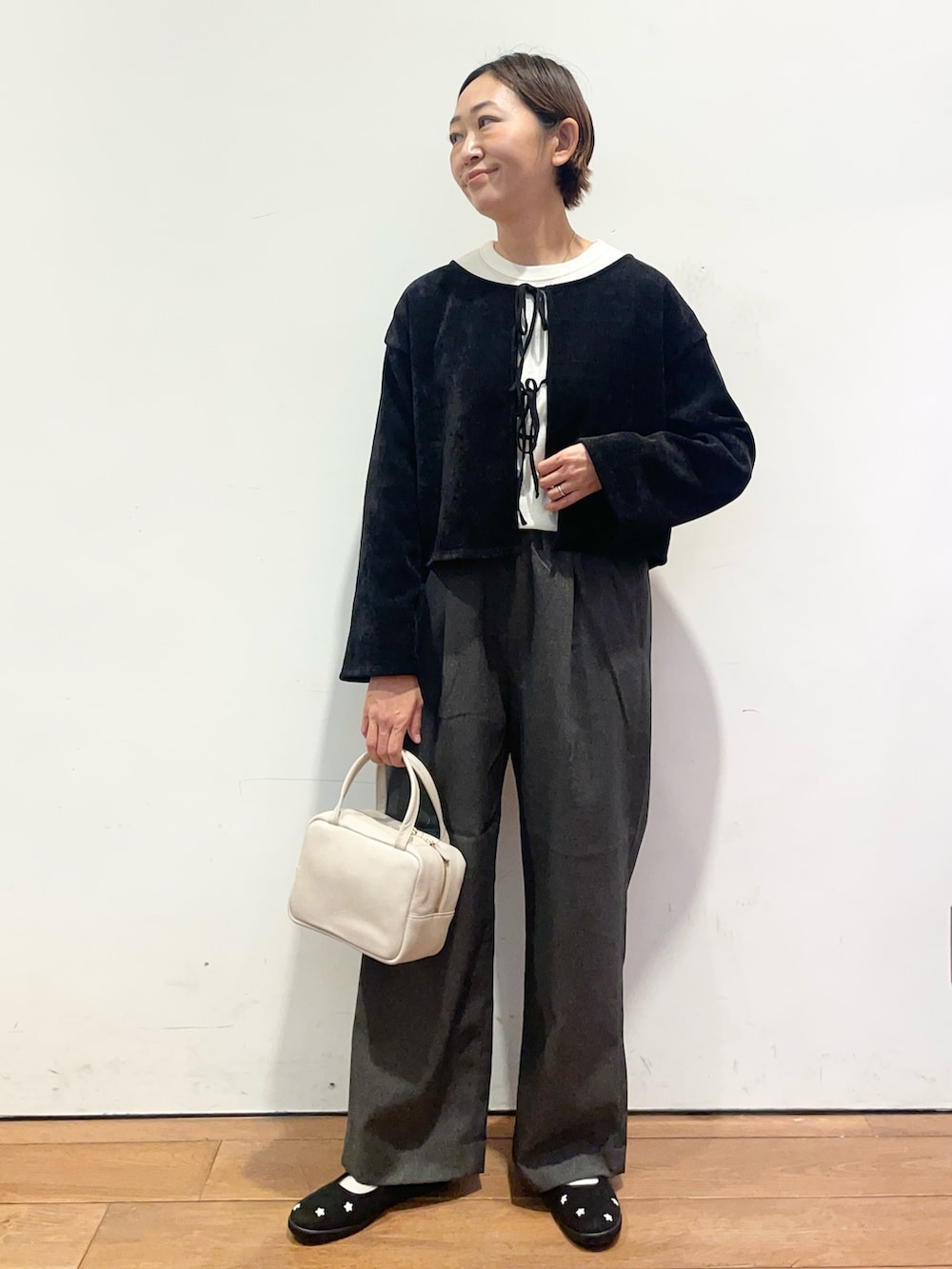 ホワイト系のTシャツ/カットソー、ブラック系のスニーカー、グレー系のボストンバッグを着用したレディースの秋コーディネートの3枚目の写真