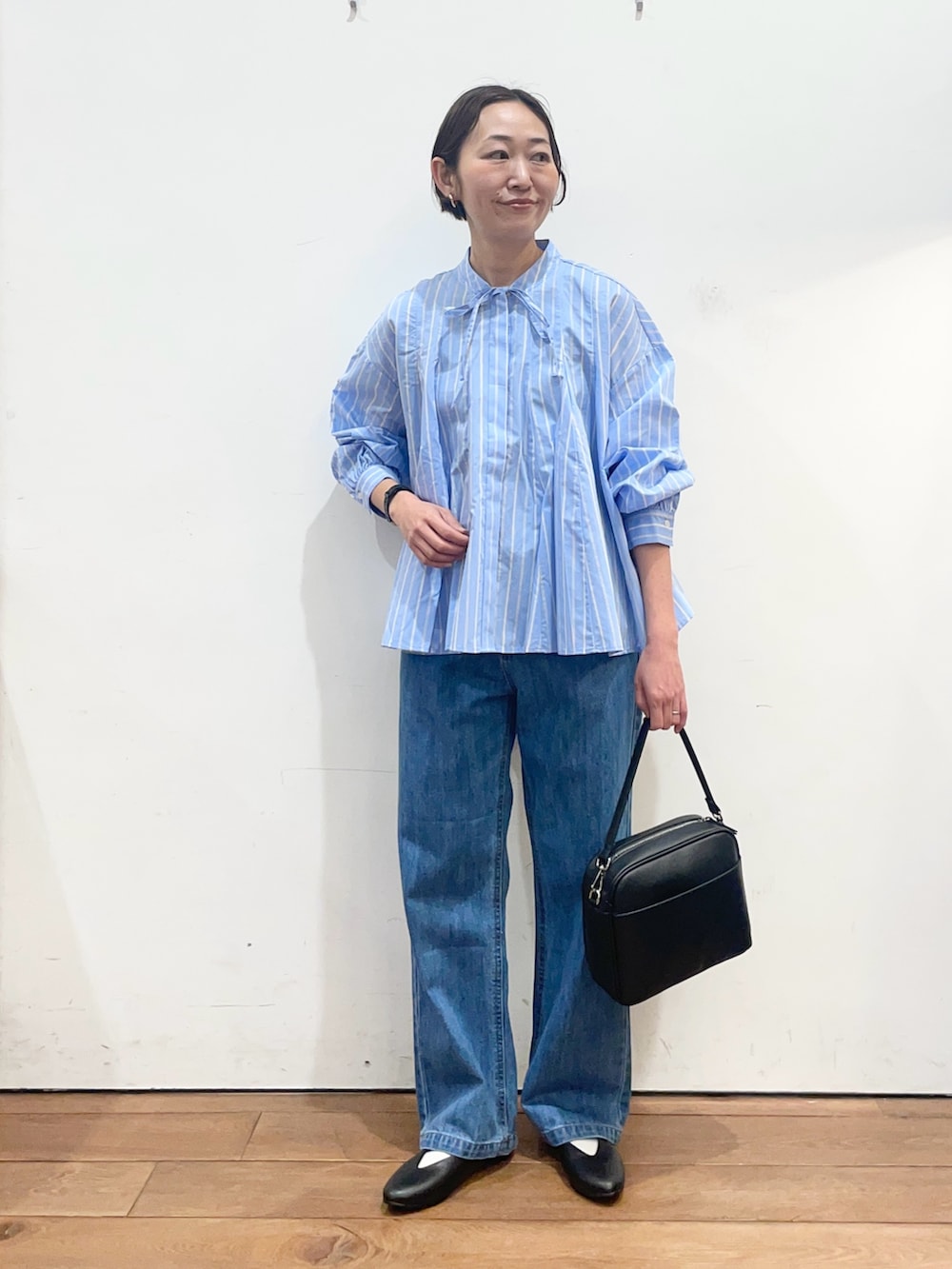 ブルー系のシャツ/ブラウス、ブラック系のショルダーバッグ、ブラック系のパンプスを着用したレディースの春コーディネートの2枚目の写真