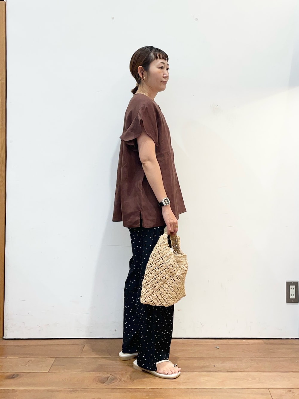 ブラウン系のシャツ/ブラウス、ブルー系のその他パンツ、ベージュ系のハンドバッグを着用したレディースの夏コーディネートの3枚目の写真