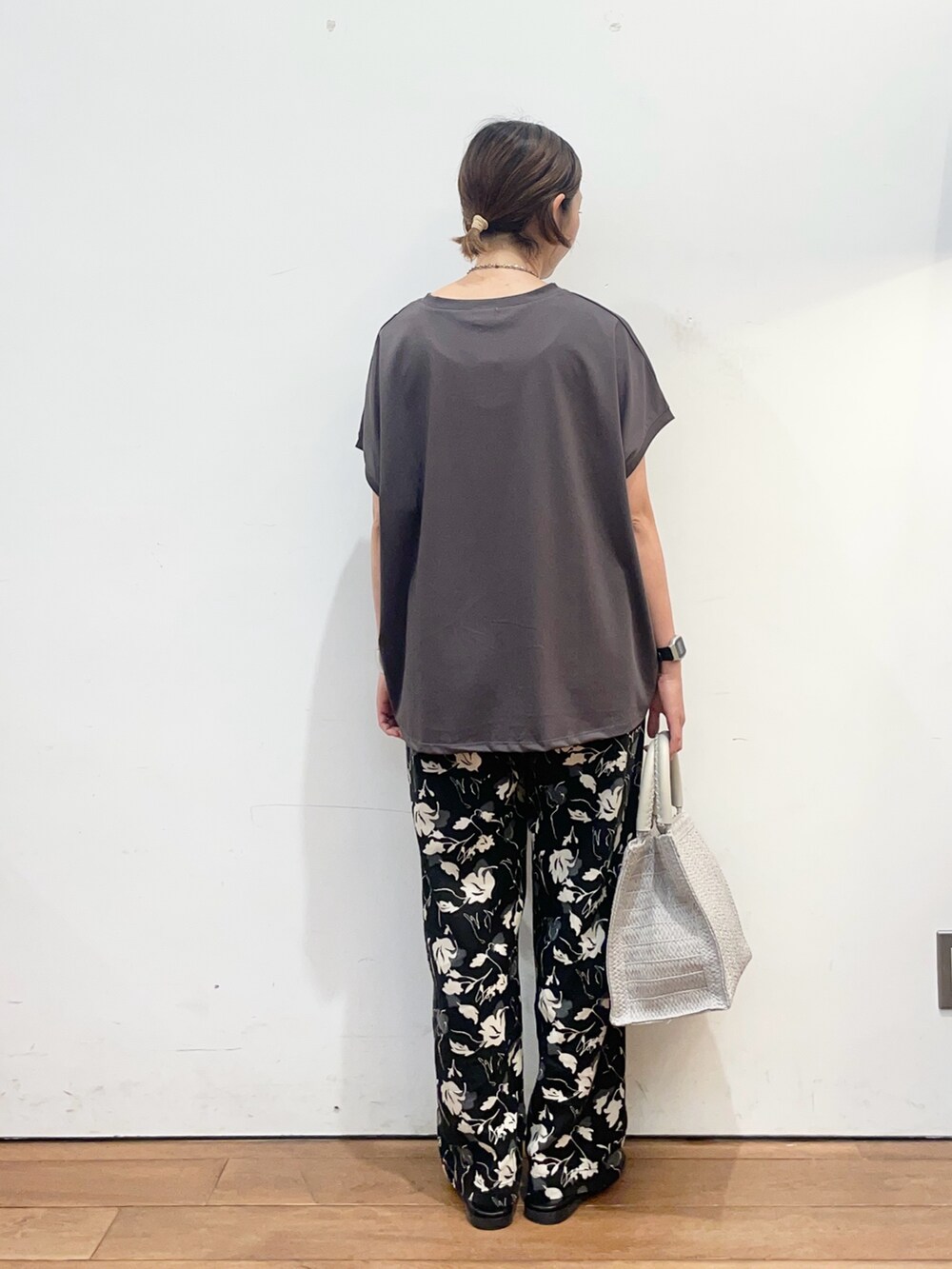 グレー系のTシャツ/カットソー、グレー系のハンドバッグ、ブラック系のサンダルを着用したレディースの夏コーディネートの5枚目の写真