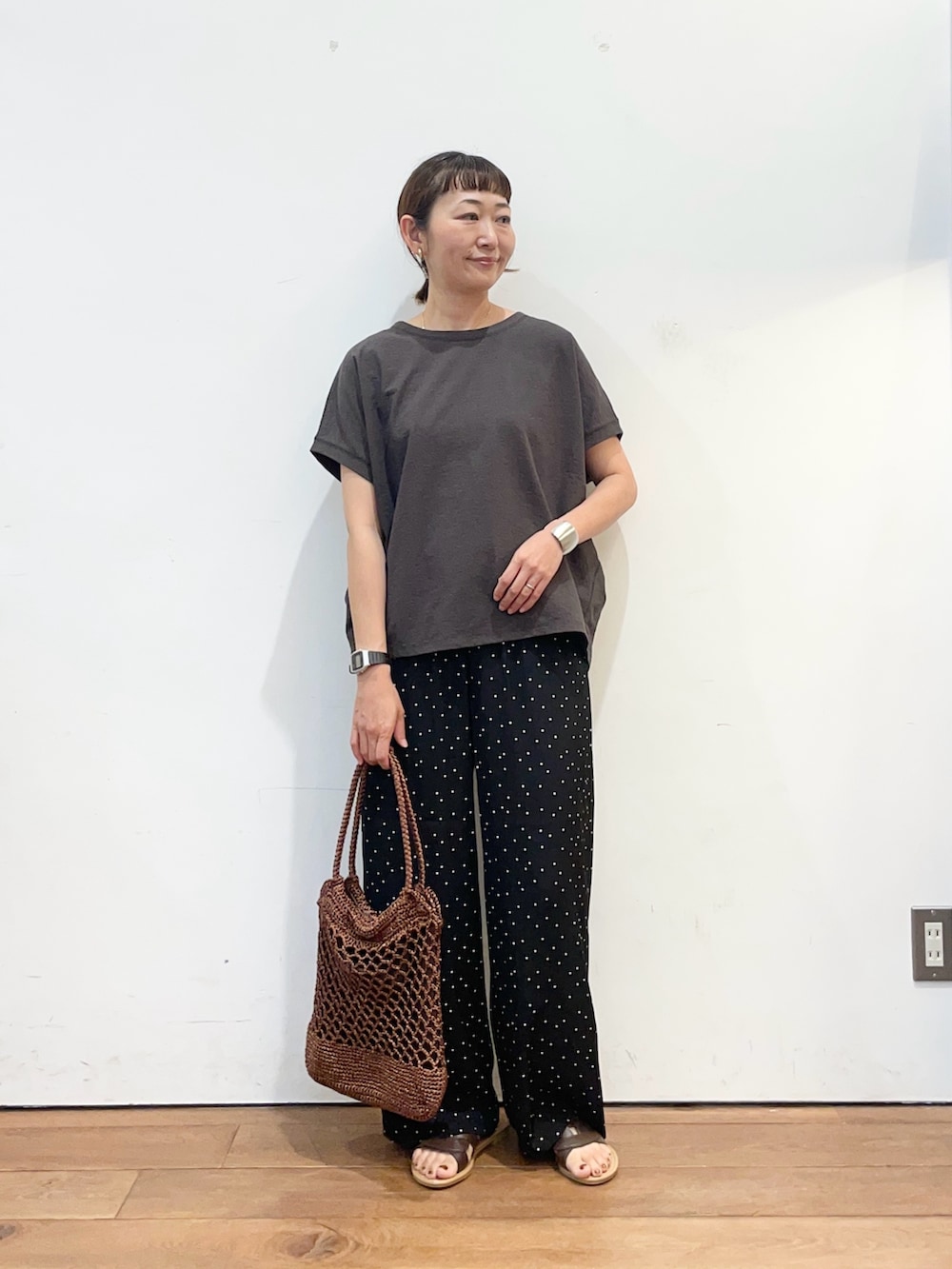 グレー系のTシャツ/カットソー、ブラウン系のサンダル、ブラック系のその他パンツを着用したレディースの夏コーディネートの2枚目の写真