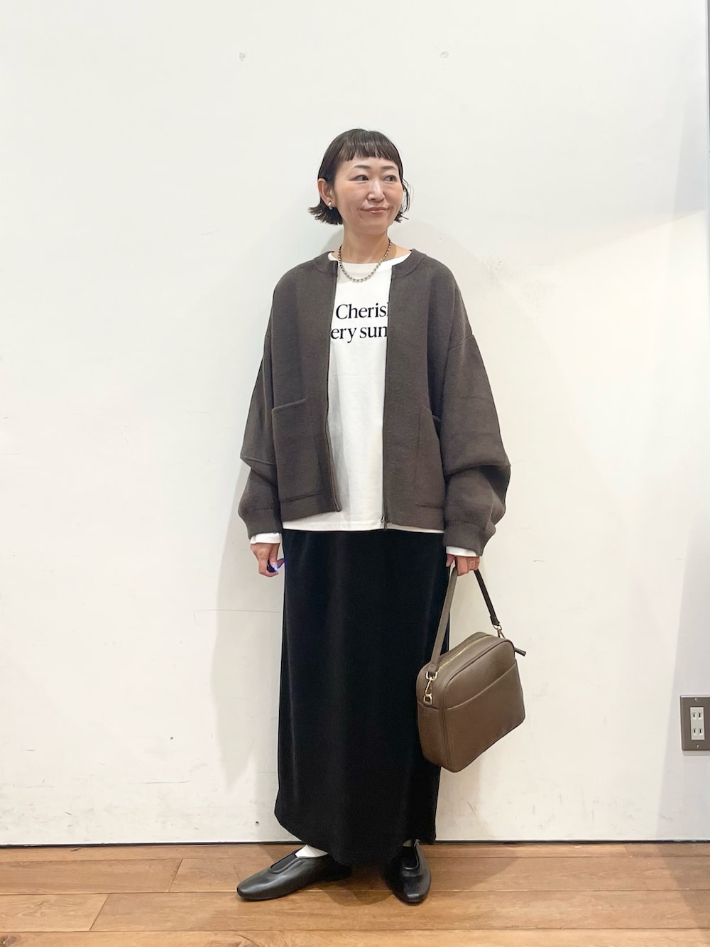 ブラウン系のブルゾン、ホワイト系のTシャツ/カットソー、ブラウン系のショルダーバッグを着用したレディースの秋コーディネートの2枚目の写真