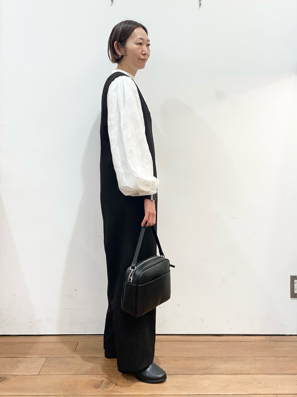 ブラック系のその他パンツ、ブラック系のショルダーバッグ、ブラック系のブーツを着用したレディースの冬コーディネートの4枚目の写真