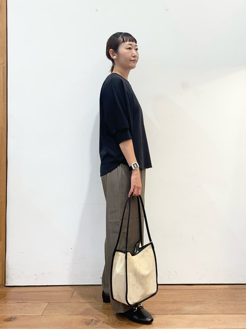 ブラック系のTシャツ/カットソー、ブラウン系のその他パンツ、ベージュ系のトートバッグを着用したレディースの秋コーディネートの3枚目の写真
