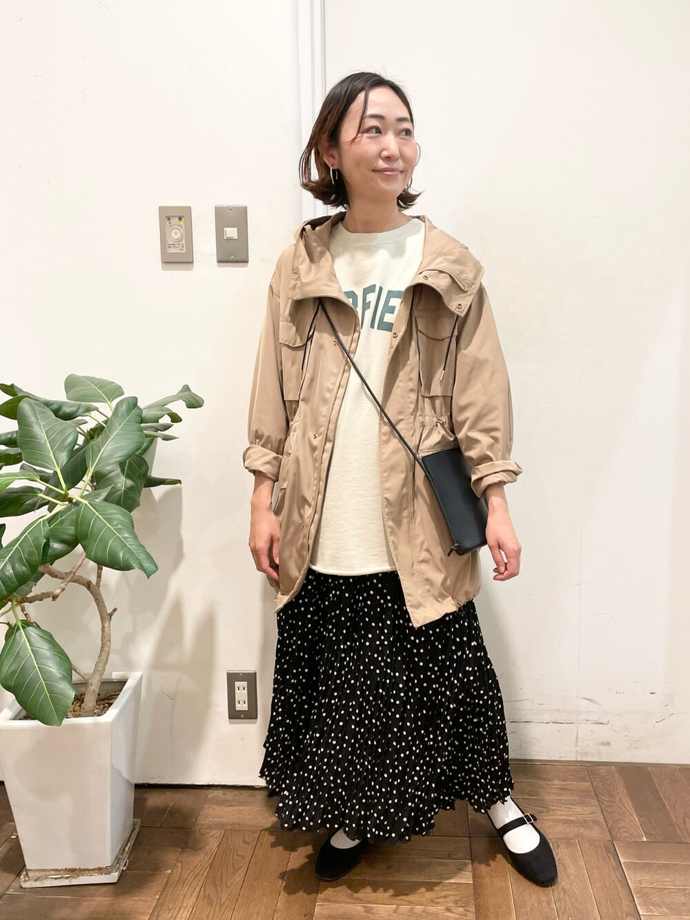 ブラック系のショルダーバッグ、ベージュ系のスウェット、ベージュ系のミリタリージャケットを着用したレディースの冬コーディネートの3枚目の写真