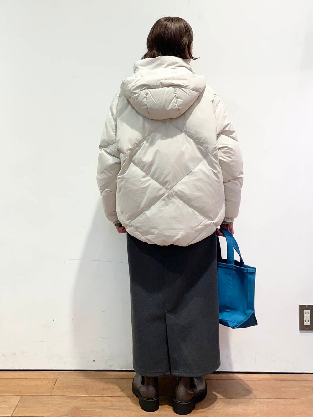 ホワイト系のダウンジャケット/コート、グレー系のニット/セーター、ブラウン系のブーツを着用したレディースの冬コーディネートの4枚目の写真