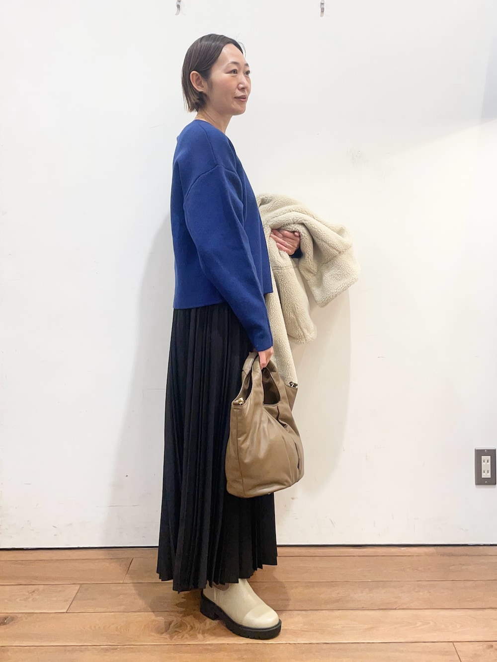 ホワイト系のその他アウター、ブルー系のニット/セーター、ブラック系のスカートを着用したレディースの冬コーディネートの7枚目の写真