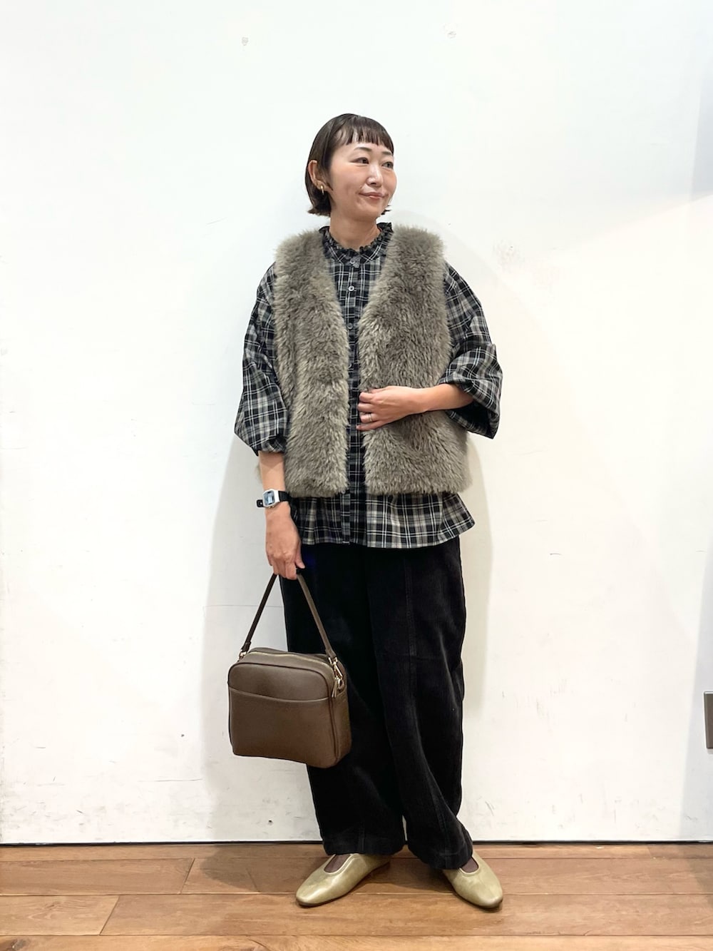 グレー系のダウンベスト、ブラック系のシャツ/ブラウス、グレー系のその他パンツを着用したレディースの秋コーディネートの3枚目の写真