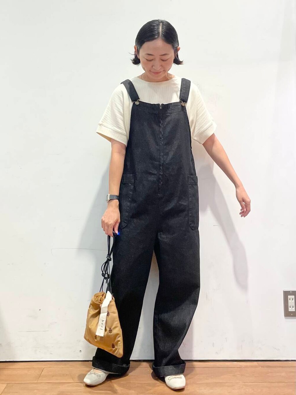 ホワイト系のTシャツ/カットソー、ブラウン系のバレエシューズ、ブラック系のサロペット/オーバーオールを着用したレディースの秋コーディネートの3枚目の写真