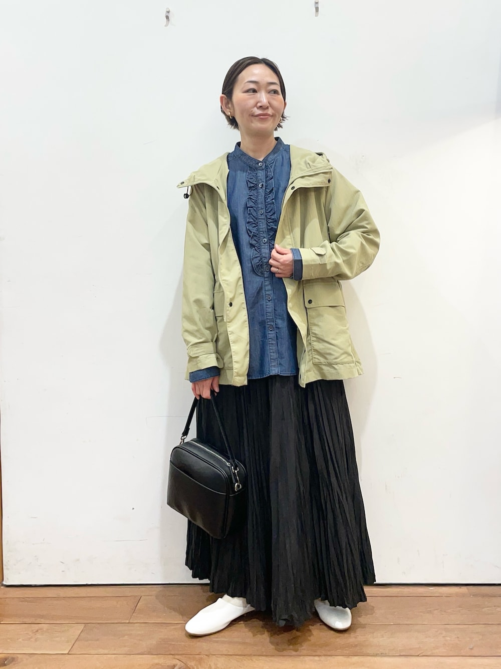 ブルー系のシャツ/ブラウス、グリーン系のマウンテンパーカー、ホワイト系のその他シューズを着用したレディースの春コーディネートの2枚目の写真