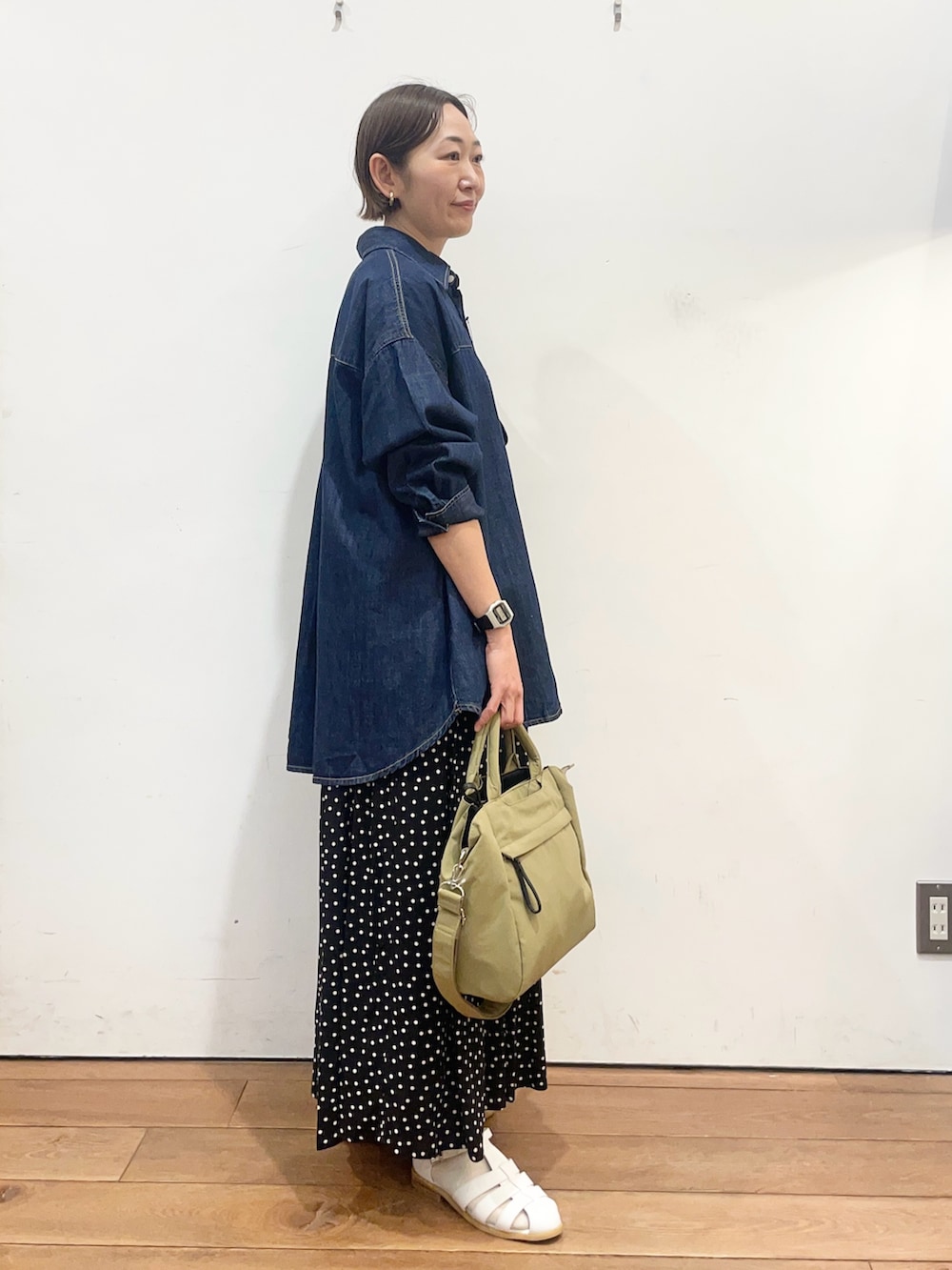 ブルー系のシャツ/ブラウス、ホワイト系のサンダル、ブラック系のスカートを着用したレディースの春コーディネートの3枚目の写真