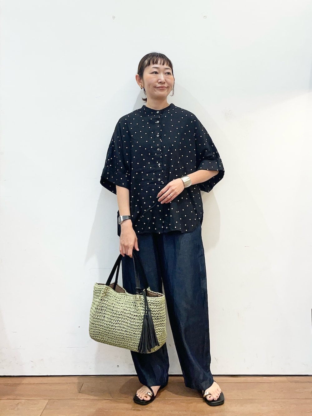 ブラック系のシャツ/ブラウス、ブラック系のサンダル、ブルー系のデニムパンツを着用したレディースの夏コーディネートの2枚目の写真