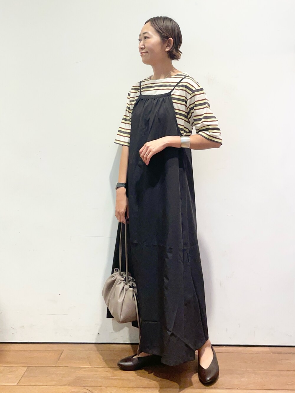 ホワイト系のTシャツ/カットソー、ブラック系のワンピース、ベージュ系のショルダーバッグを着用したレディースの夏コーディネートの3枚目の写真