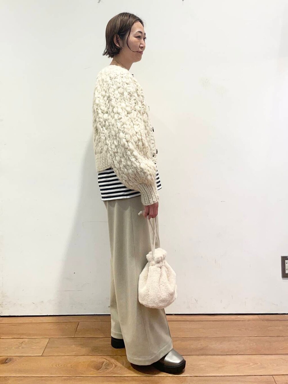 ホワイト系のカーディガン/ボレロ、シルバー系のブーツ、ベージュ系のその他パンツを着用したレディースの冬コーディネートの3枚目の写真