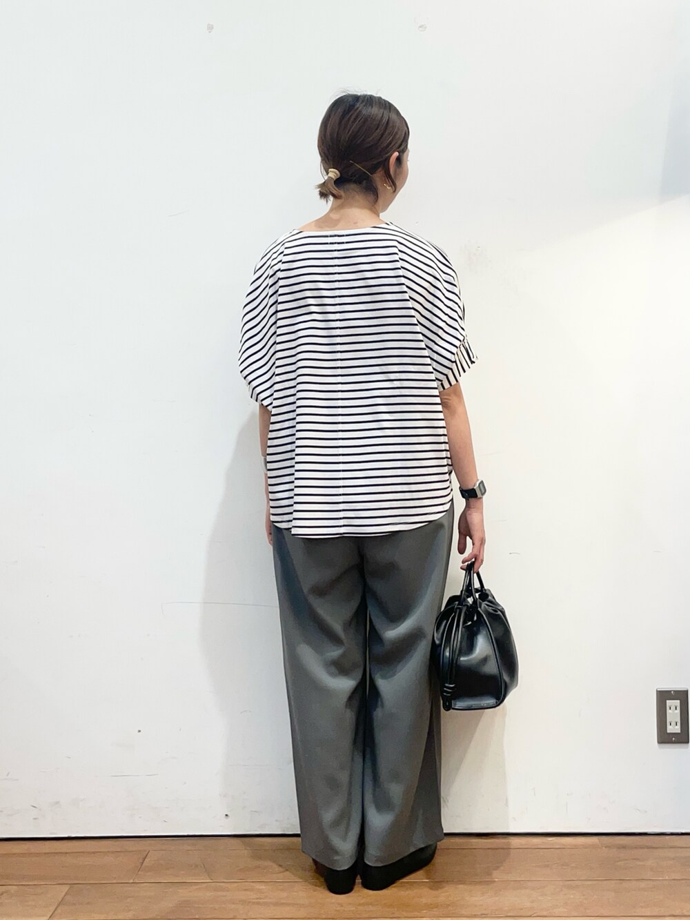 ホワイト系のTシャツ/カットソー、ブラック系のパンプス、ブラック系のトートバッグを着用したレディースの春コーディネートの5枚目の写真