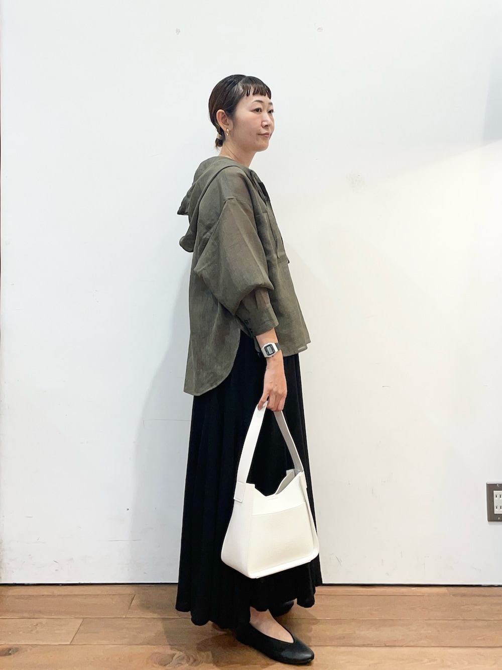 グレー系のシャツ/ブラウス、ブラック系のスカート、ホワイト系のハンドバッグを着用したレディースの秋コーディネートの3枚目の写真