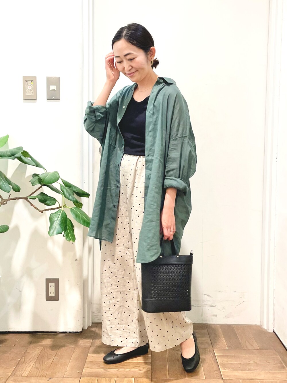 ブラック系のタンクトップ、グリーン系のシャツ/ブラウス、ベージュ系のその他パンツを着用したレディースの春コーディネートの2枚目の写真