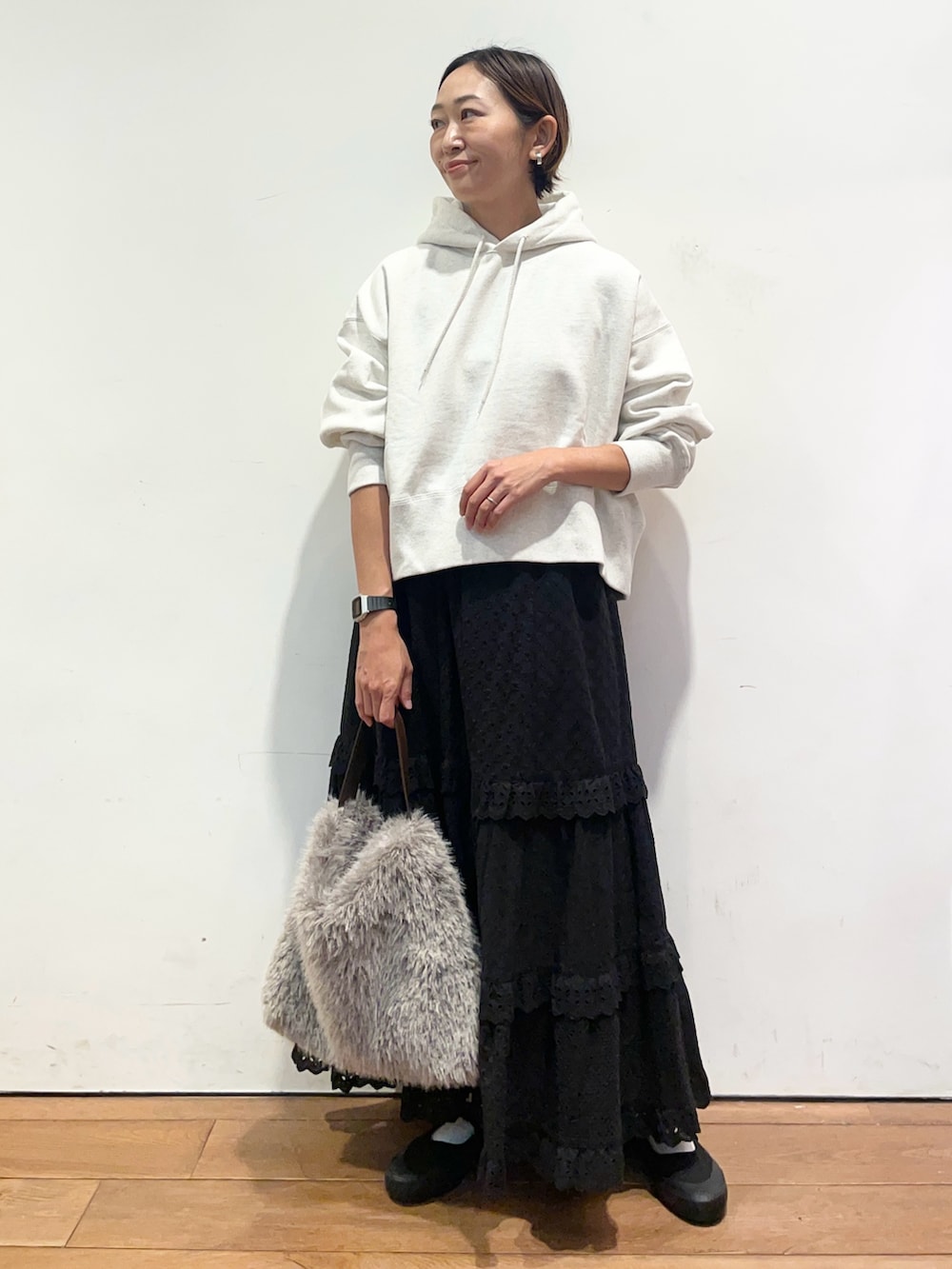 ベージュ系のパーカー、ブラック系のスカート、ブラック系のバレエシューズを着用したレディースの秋コーディネートの2枚目の写真