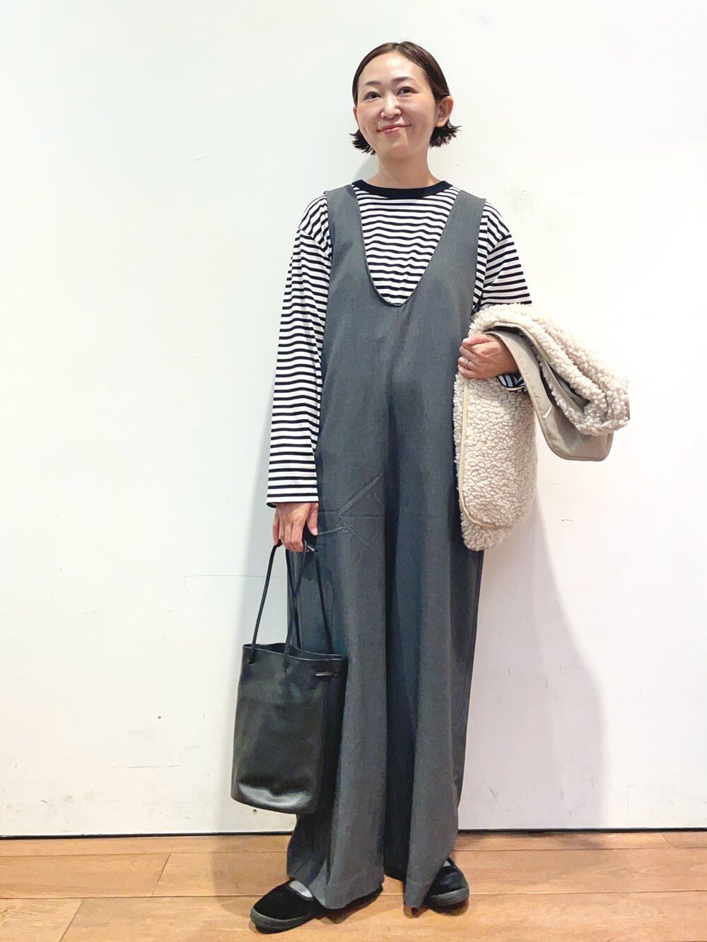 ブラック系のTシャツ/カットソー、ベージュ系のベスト、グレー系のサロペット/オーバーオールを着用したレディースの秋コーディネートの4枚目の写真
